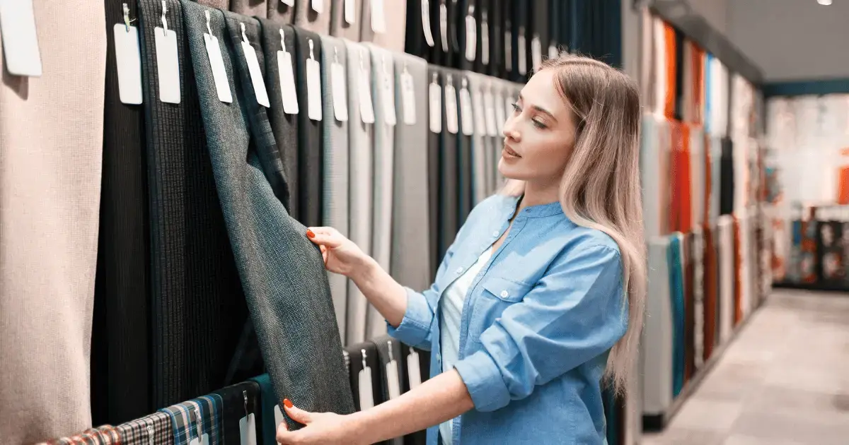 a woman looking at fabric in a fabric store